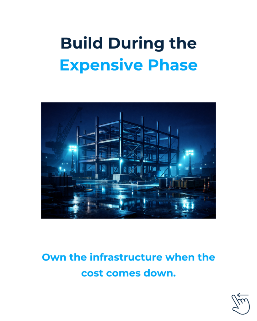Steel frame of a building under construction at night.
