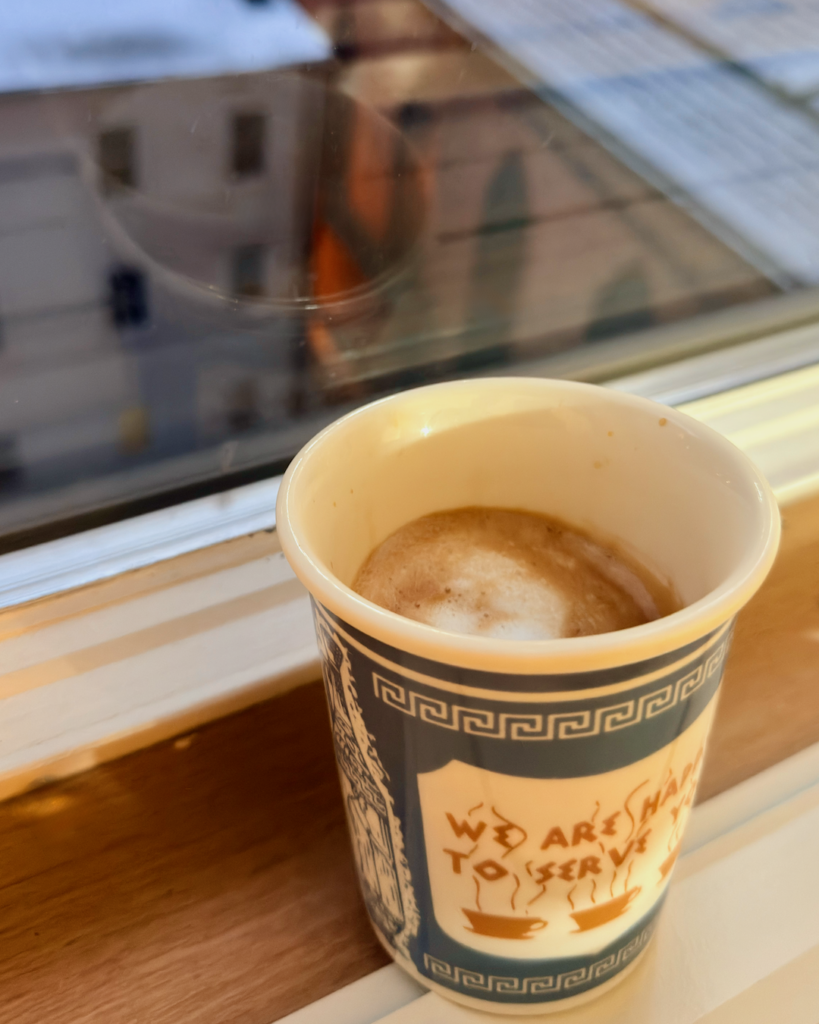 A cup of coffee by a sunny window with a handwritten note.